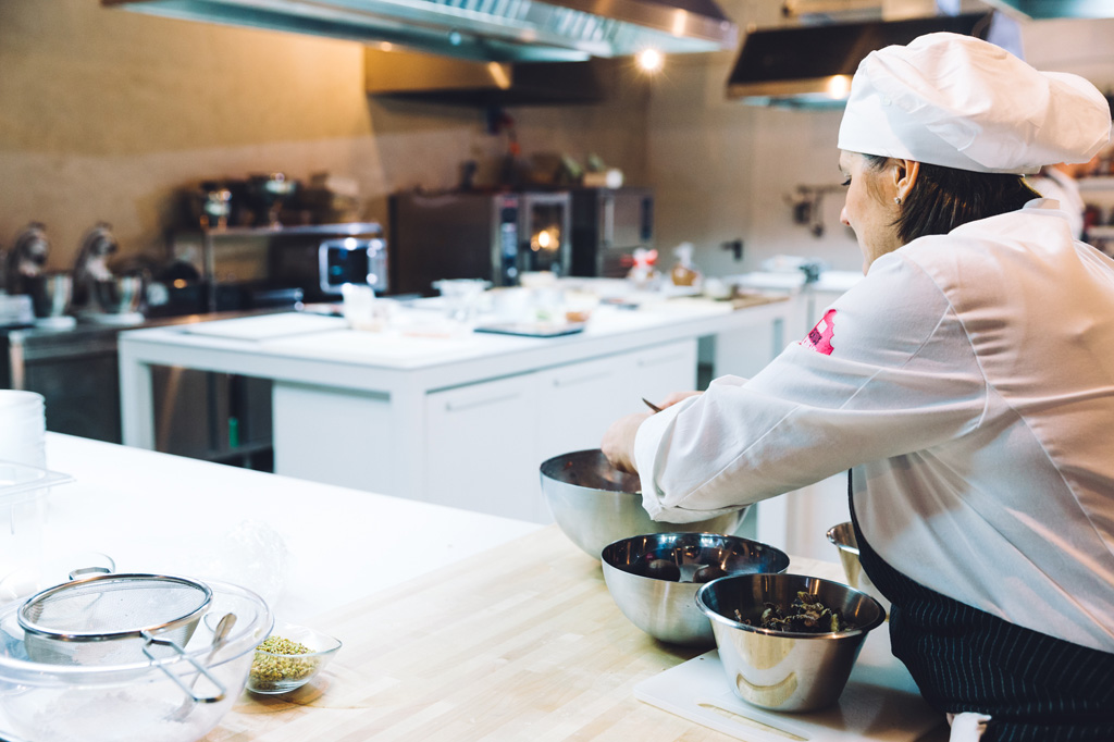 Una cuoca taglia il cioccolato in cucina