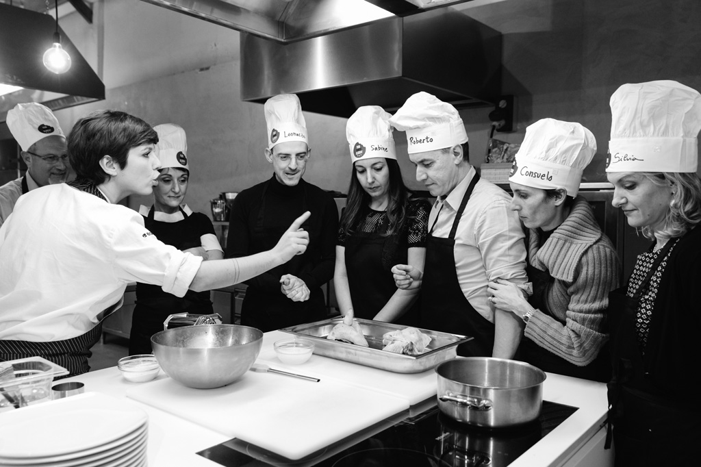 Una cuoca spiega dettagliatamente ai clienti come lavorare