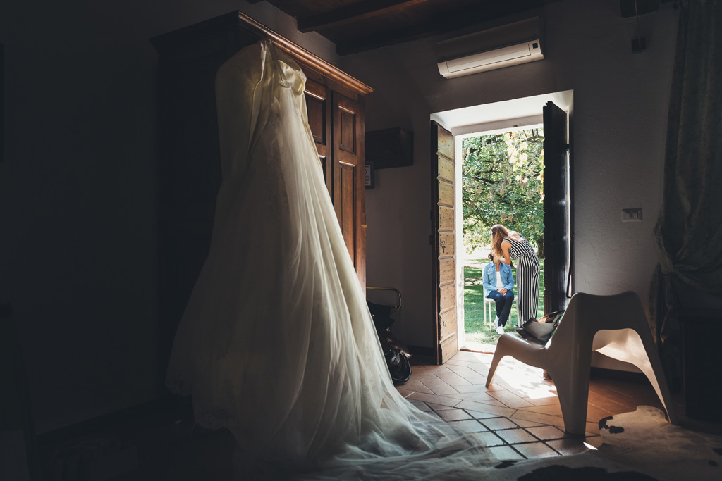 Fotografo Matrimonio Pavia Il vestito della sposa Silvia è illuminato da una morbida luce dalla porta