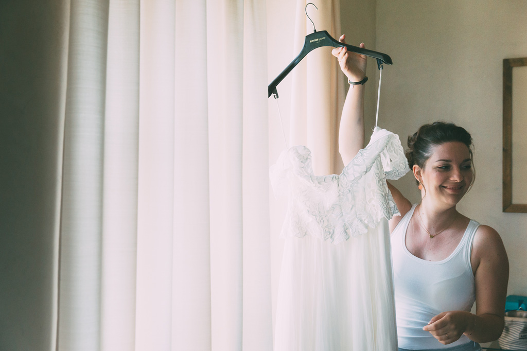 La sposa sostiene orgogliosa il suo abito