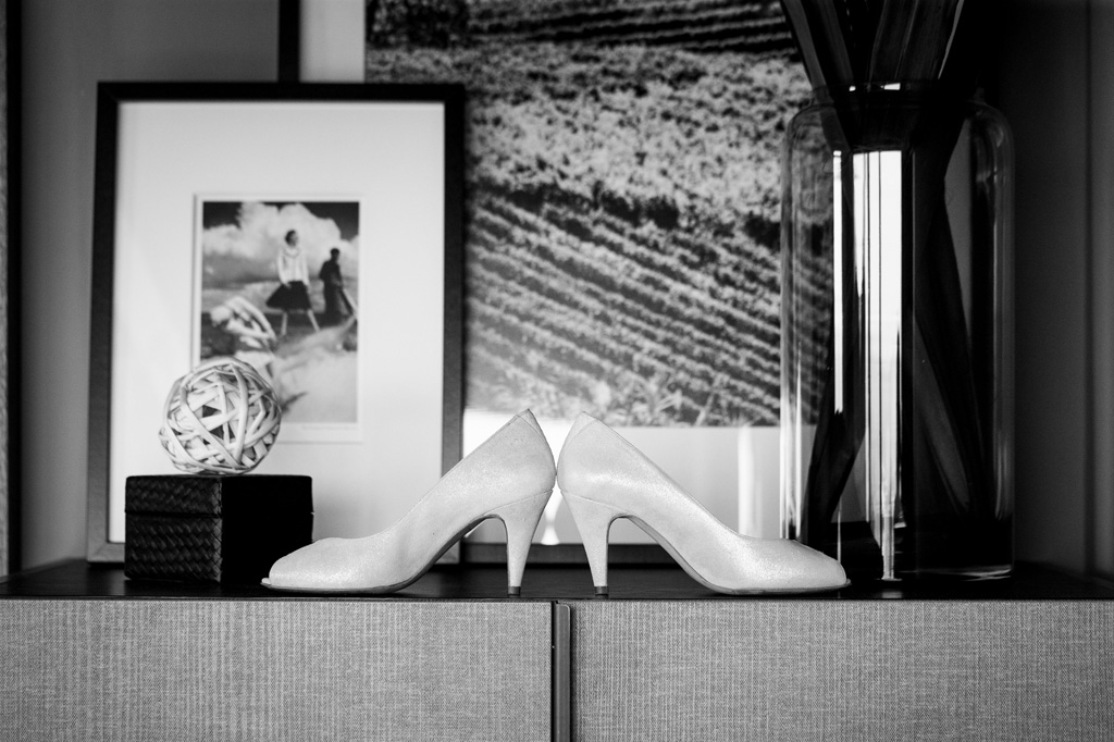 Fotografo Matrimonio Langhe L'eleganza delle scarpe della sposa riprese davanti a delle fotografie incorniciate