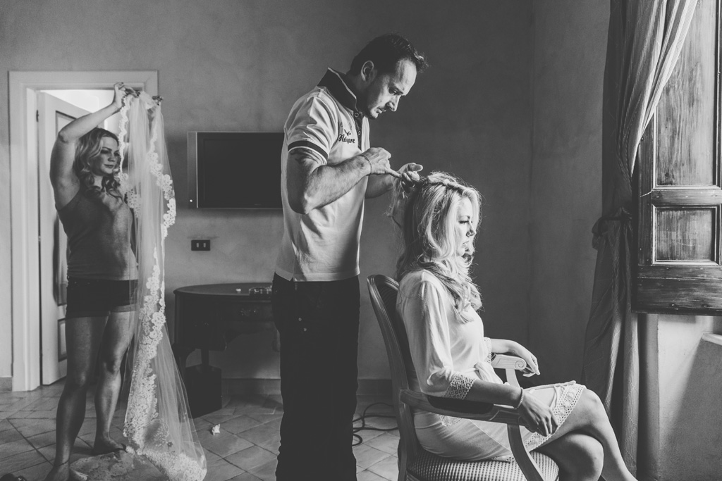 Il parrucchiere sistema i capelli di Brittney durante la preparazione