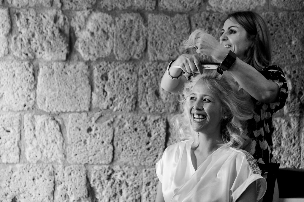 La parrucchiera acconcia la sposa in vista delle nozze di matrimonio