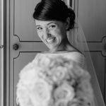La sposa è in posa con un mazzo di fiori per il fotografo