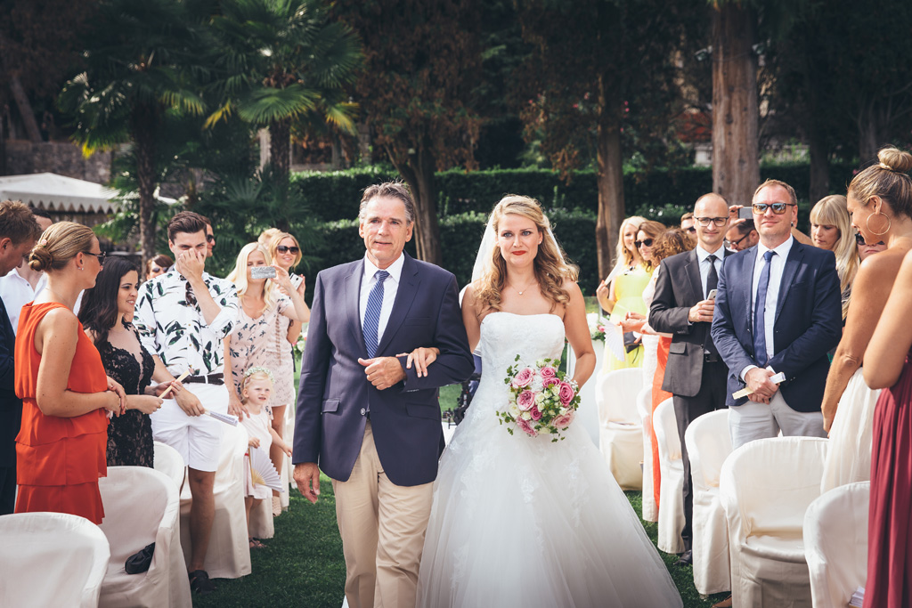Il padre tiene a braccetto Katrin lungo il corridoio