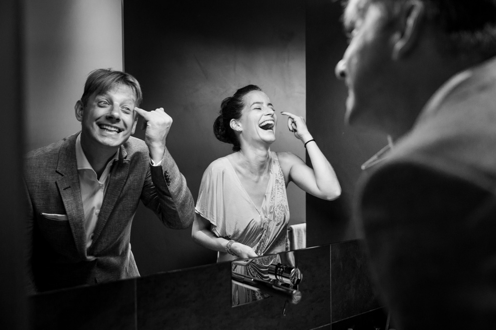 Fotografo Matrimonio Langhe Lo sposo ride di fronte allo specchio durante la preparazione