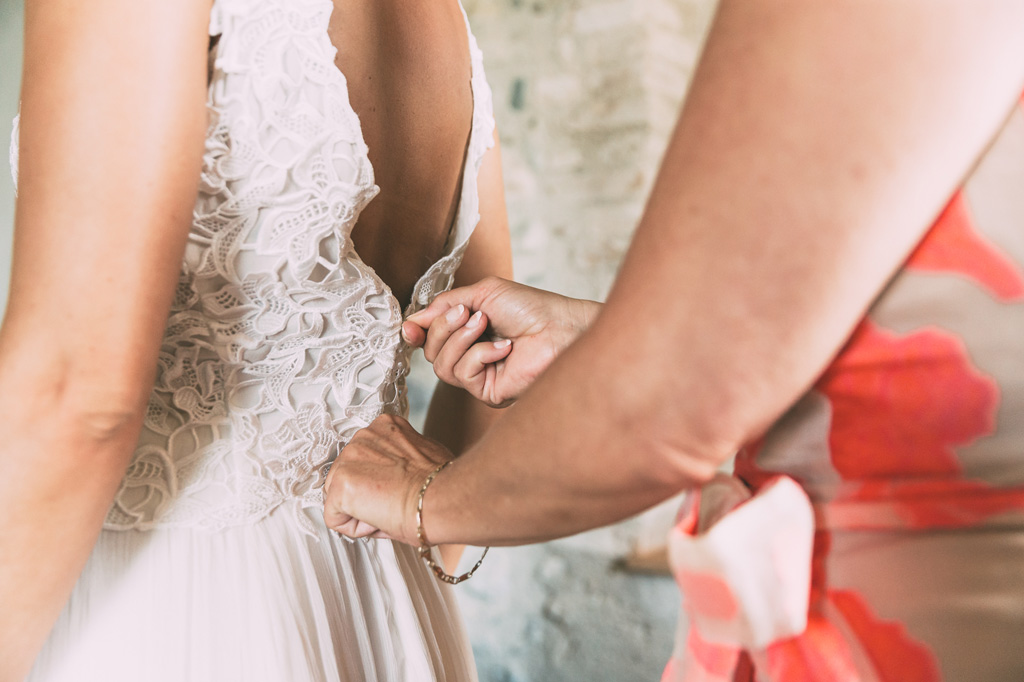 La madre della sposa sistema il vestito della sposa