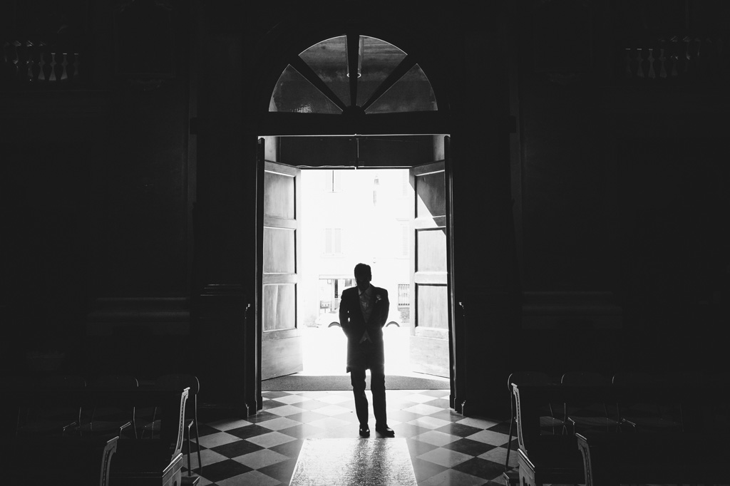 Fotografo Matrimonio Villa Caroli Zanchi Il primo invitato alla cerimonia attende paziente nella chiesa a Bergamo