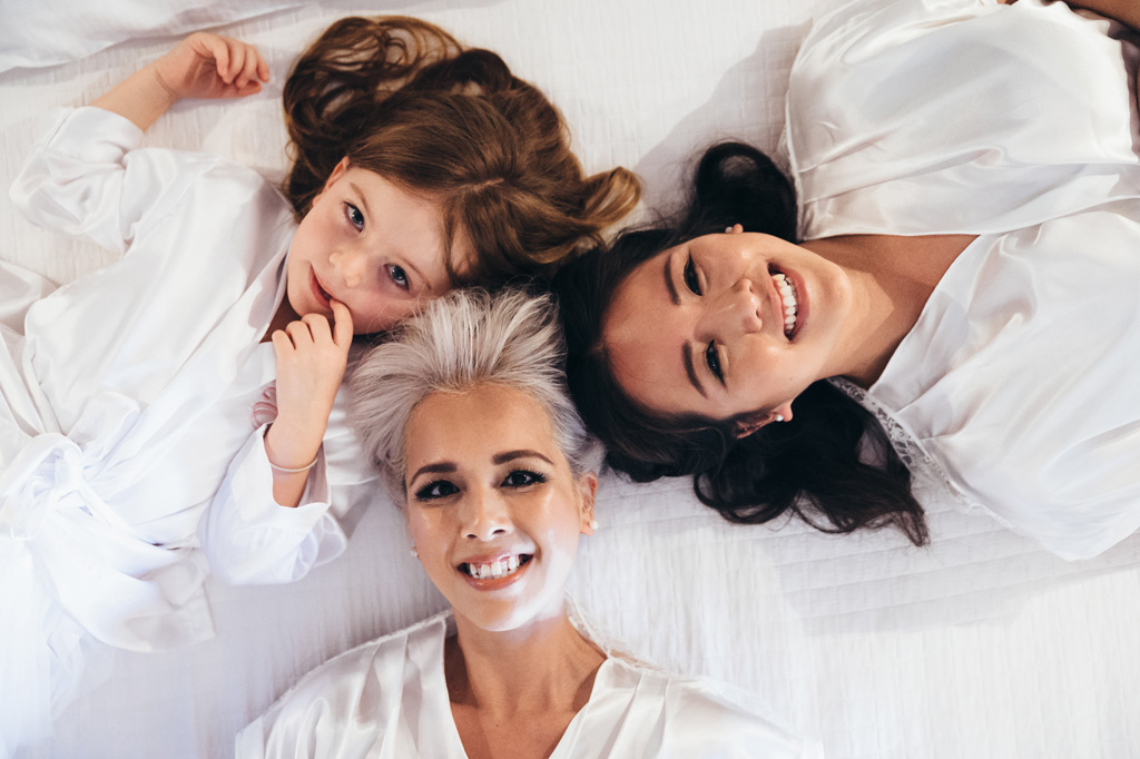 La sposa sorride in compagnia di una damigella e una bambina