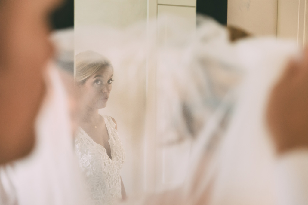 La sposa si specchia davanti allo specchio in un gioco di riflessi scattato da Alessandro Della Savia
