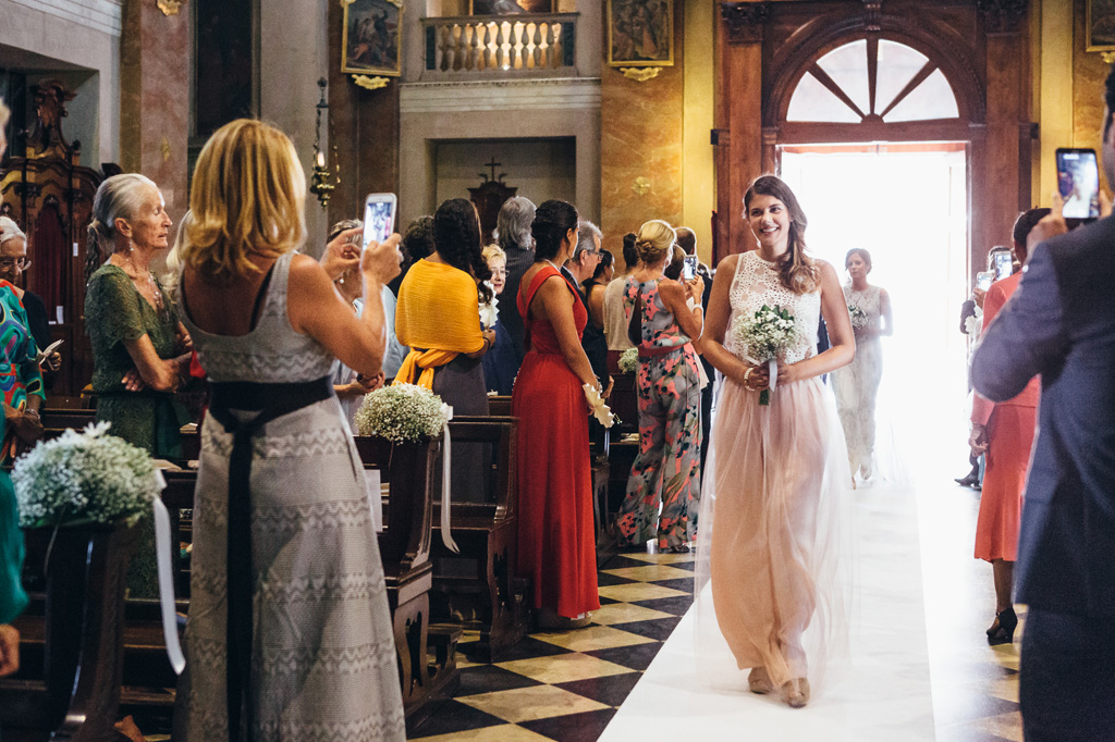 Fotografo Matrimonio Villa Caroli Zanchi Le damigelle attraversano la navata con un sorriso dolce