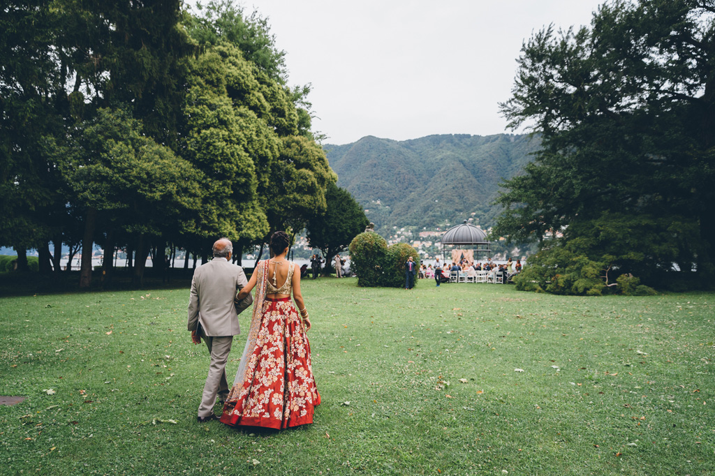 Il padre cammina a braccetto con la sposa in direzione del luogo della cerimonia