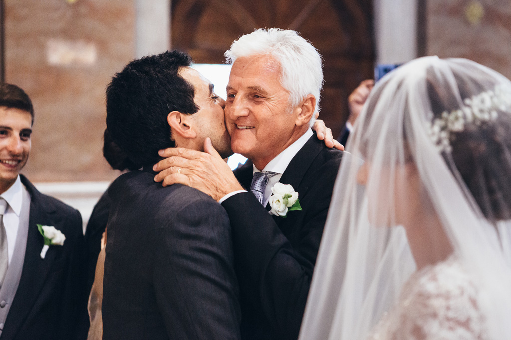 Fotografo Matrimonio Villa Caroli Zanchi Riccardo bacia il padre della sposa in un momento toccante immortalato da Alessandro Della Savia