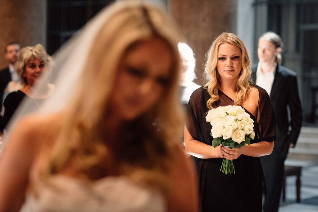 Una damigella guarda la sposa durante la cerimonia