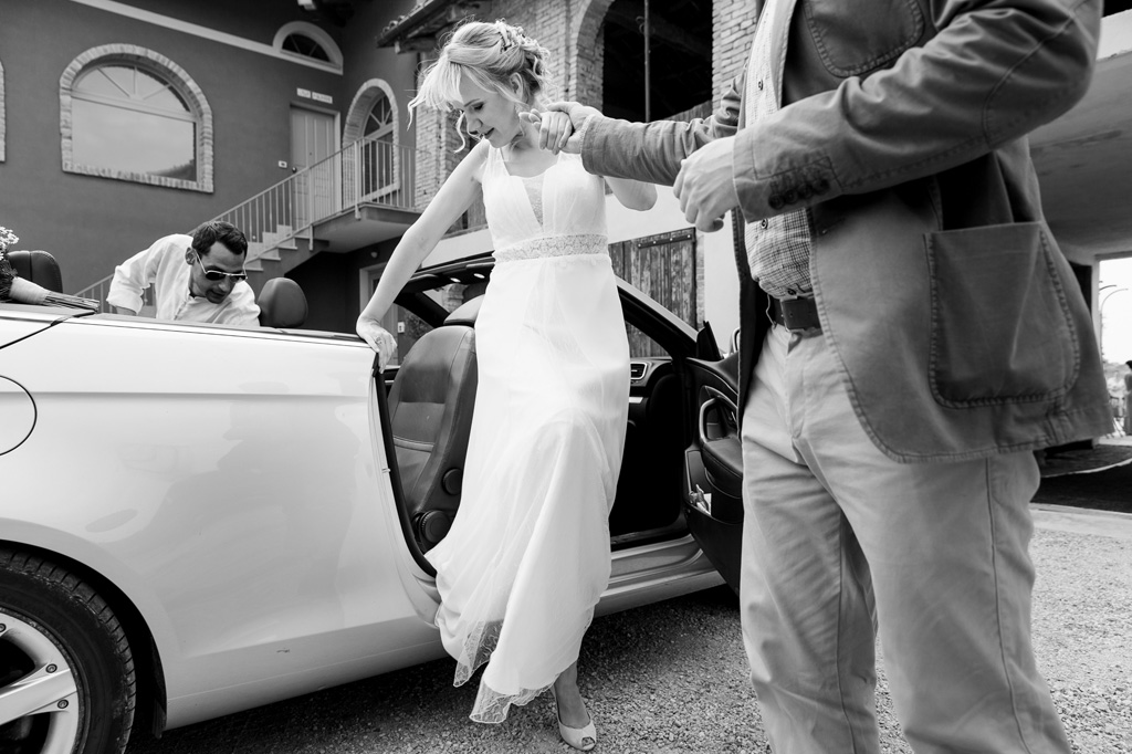Fotografo Matrimonio Langhe La sposa Tatiana scende dalla macchina accompagnata da un parente