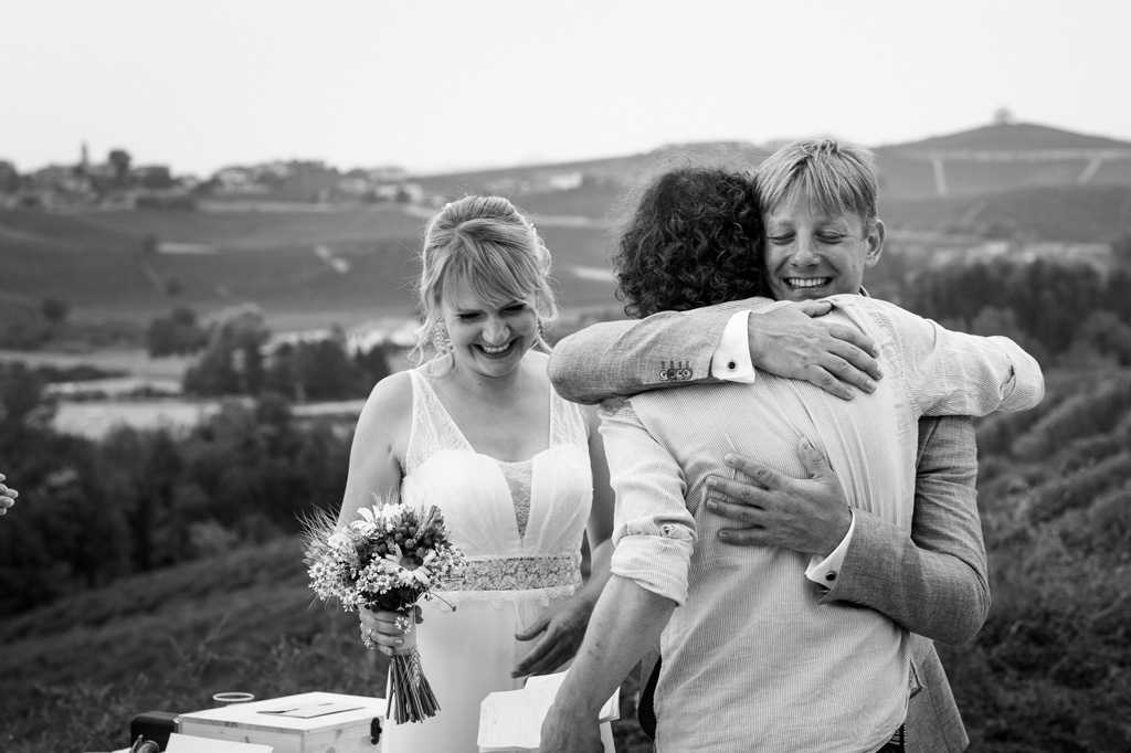 Fotografo Matrimonio Langhe Gli sposi abbracciano un ospite
