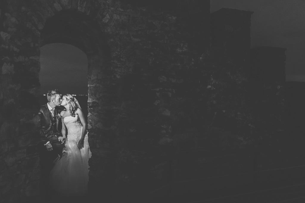 I due sposi si baciano in una atmosfera di un castello diroccato nei pressi del Lago di Garda
