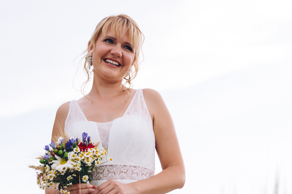 Fotografo Matrimonio Langhe Tatiana sorride con il bouquet in mano ritratta da Alessandro Della Savia