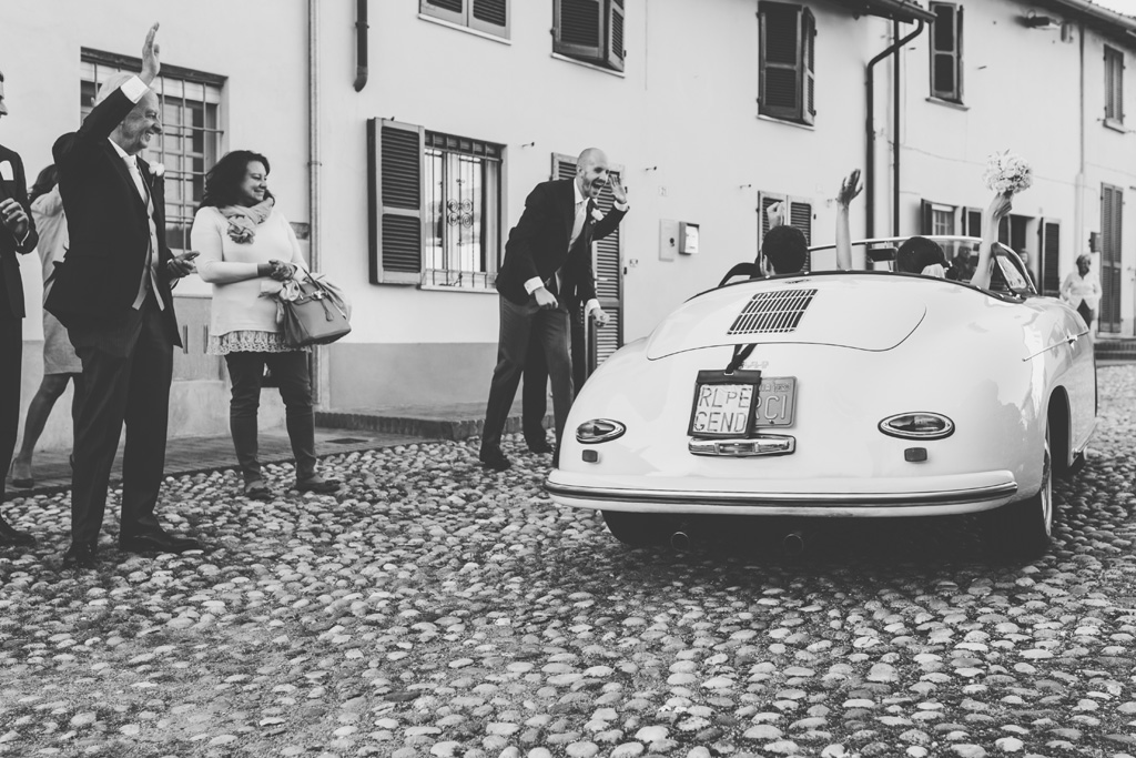Fotografo Matrimonio Pavia Gli sposi, Federico e Silvia, salutano gli ospiti dalla macchina