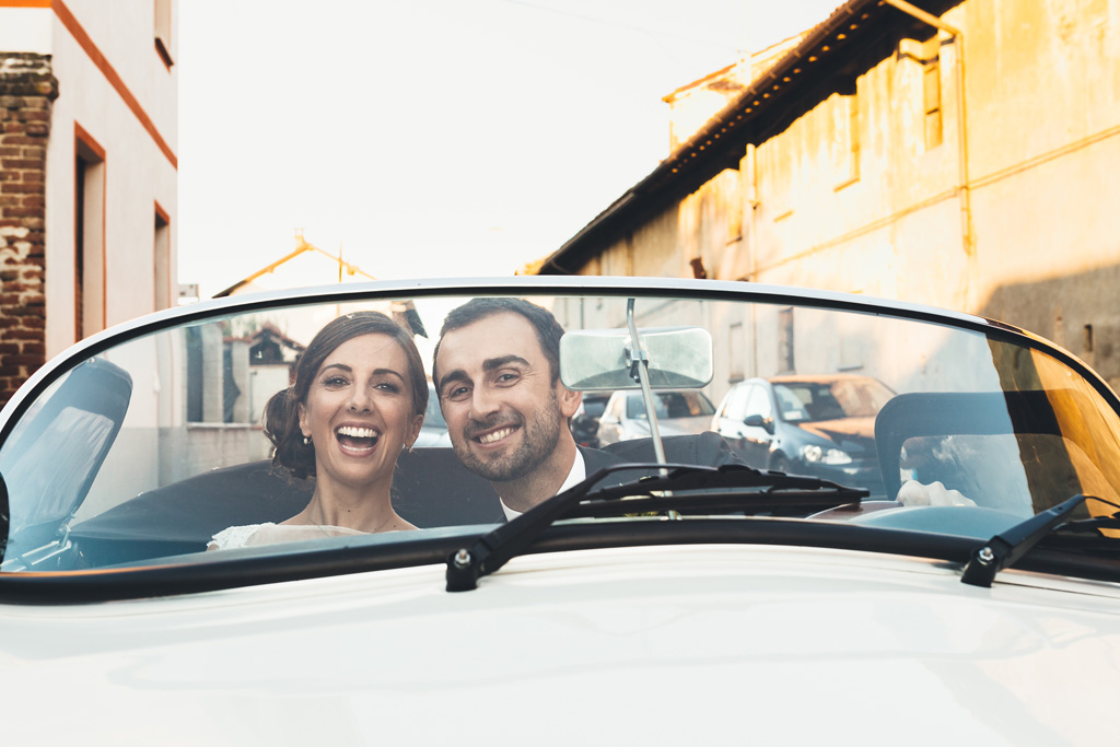 Fotografo Matrimonio Pavia Gli sposi sono ritratti mentre girano intorno a Pavia in sella a una Porsche
