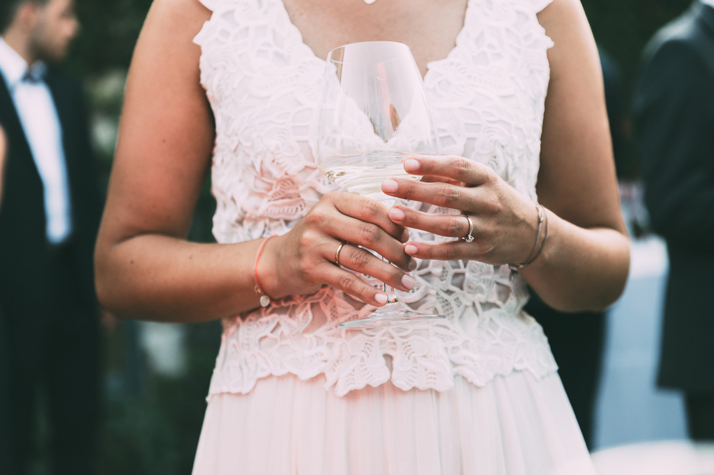 La sposa beve un bicchiere di spumante durante la festa di ricevimento