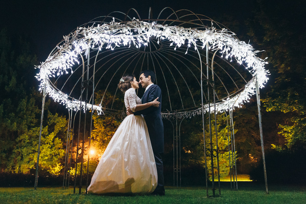 Fotografo Matrimonio Villa Caroli Zanchi Gli sposi, Riccardo e Beatrice, si guardano intensamente sotto il gazebo adornato e illuminato di Villa Caroli