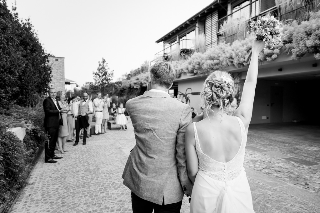 Fotografo Matrimonio Langhe La sposa Tatiana alza il bouquet in cielo