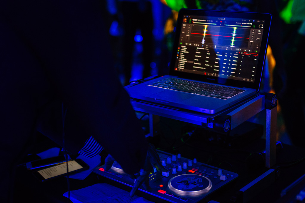 Fotografo Matrimonio Villa Erba Il dj suona una canzone per gli invitati sotto tra le luci blu del locale