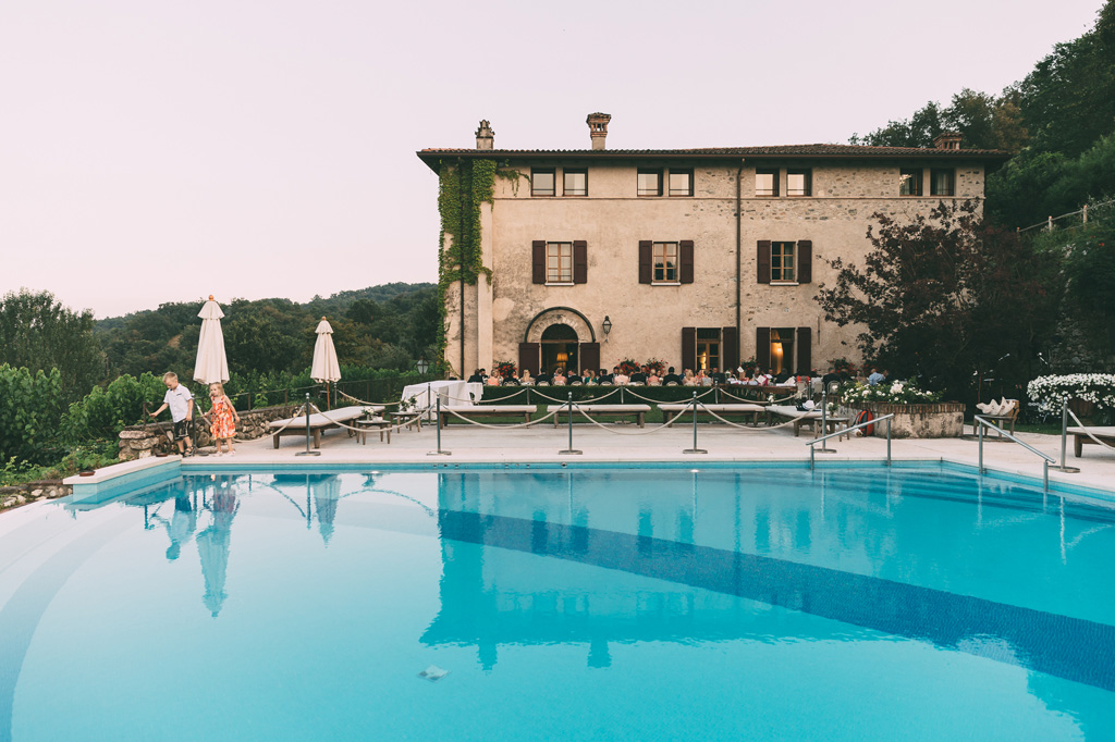 Due bambini giocano sul bordo della piscina