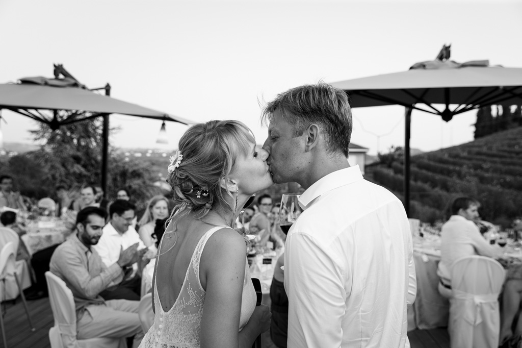 Fotografo Matrimonio Langhe I due sposi si baciano nella sala di ricevimento
