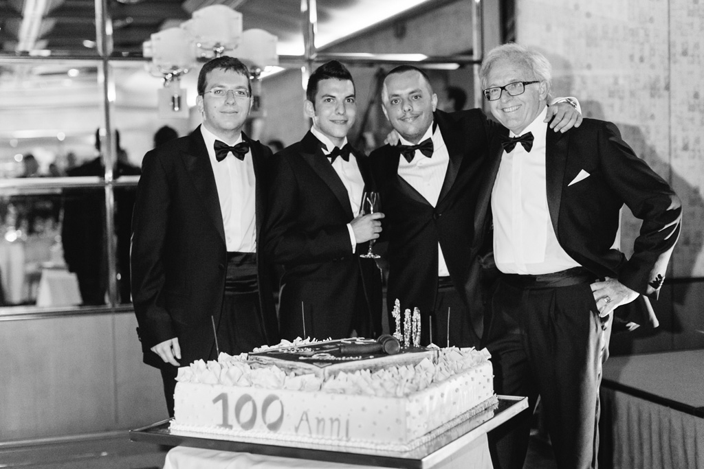 Gli avvocati posano con la torta del centesimo anniversario dello studio Paltrinieri