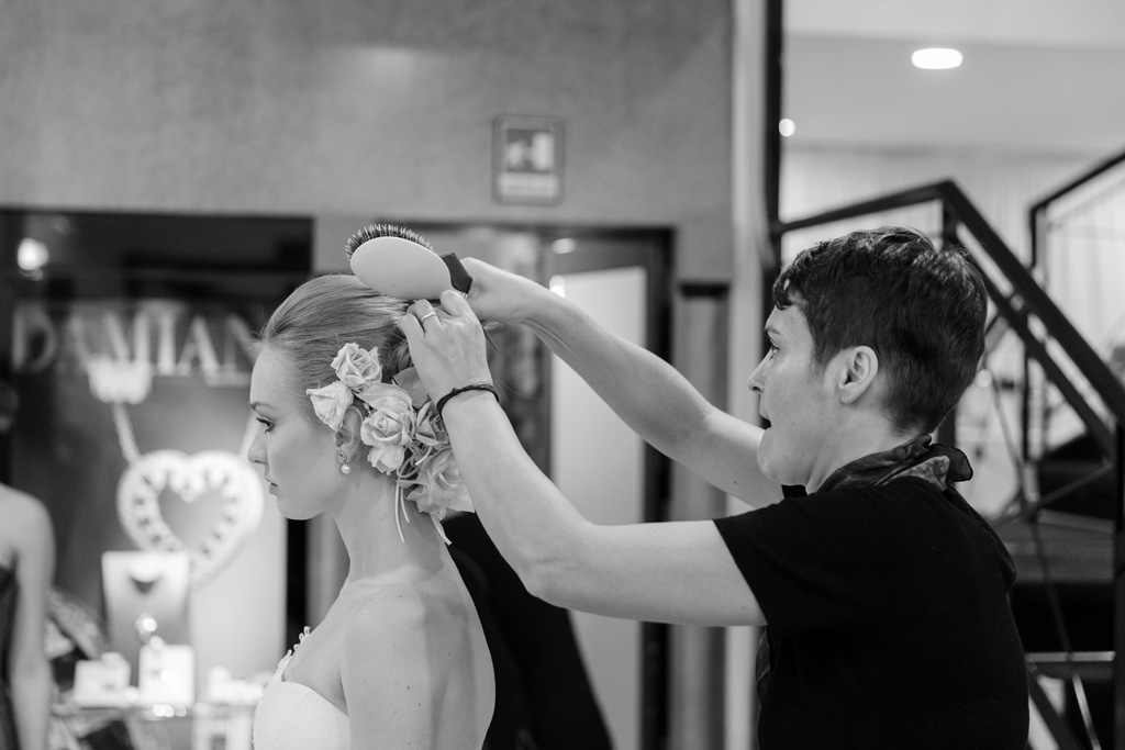 Un parrucchiere acconcia la sposa per l'evento organizzato da Vogue Sposa
