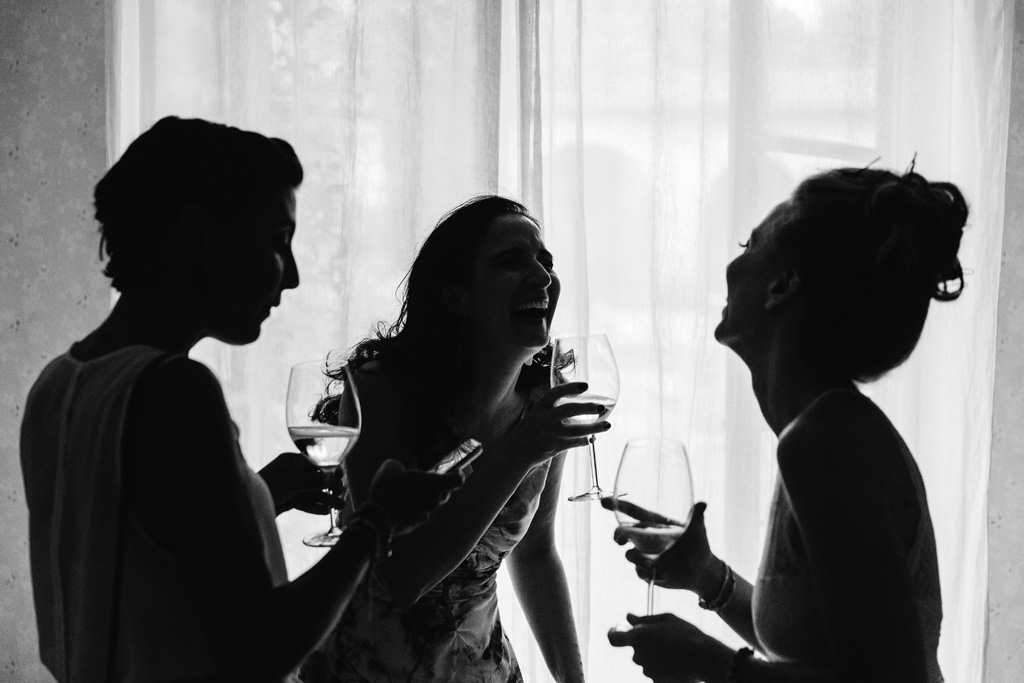 Fotografo Matrimonio Convento Dell'Annunciata Medole Silhouettes della sposa e delle amiche che ridono davanti alla finestra