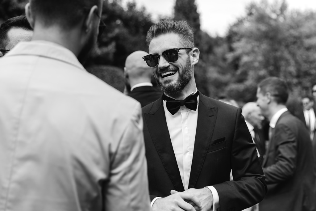 Fotografo Matrimonio Convento Dell'Annunciata Medole Lo sposo con gli occhiali da sole parla con gli invitati