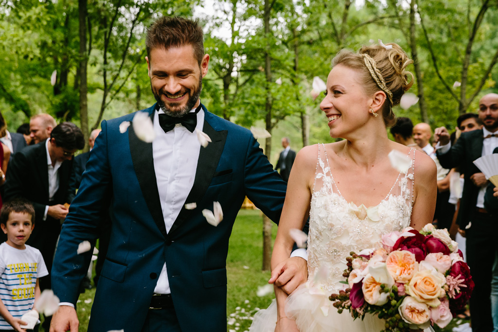 Fotografo Matrimonio Convento Dell'Annunciata Medole Gli sposi si guardano divertiti mentre cadono ancora petali di rose