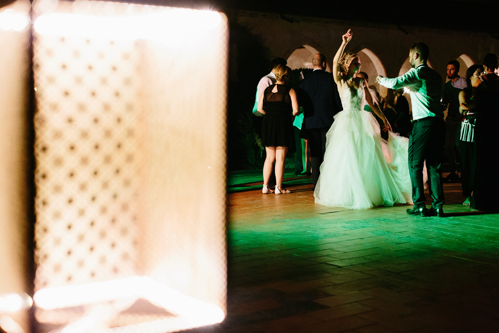 Fotografo Matrimonio Convento Dell'Annunciata Medole Laura e Matteo ballano insieme divertendosi sotto le luci verdi del Convento dell'Annunciata