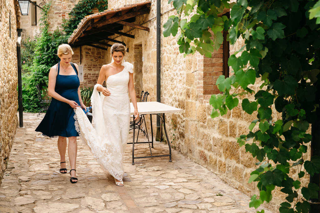 Fotografo Matrimonio Basilica San Galgano Toscana La sposa esce dalla stanza con la damigella e si dirige verso la macchina