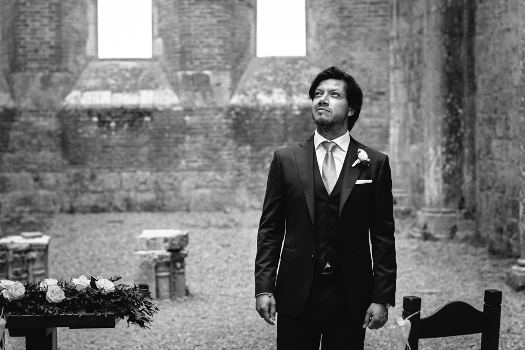 Fotografo Matrimonio Basilica San Galgano Toscana Lo sposo guarda il cielo terso oltre le mura dell'Abbazia di San Galgano