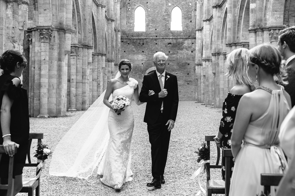 Fotografo Matrimonio Basilica San Galgano Toscana La sposa e il padre arrivano dagli invitati