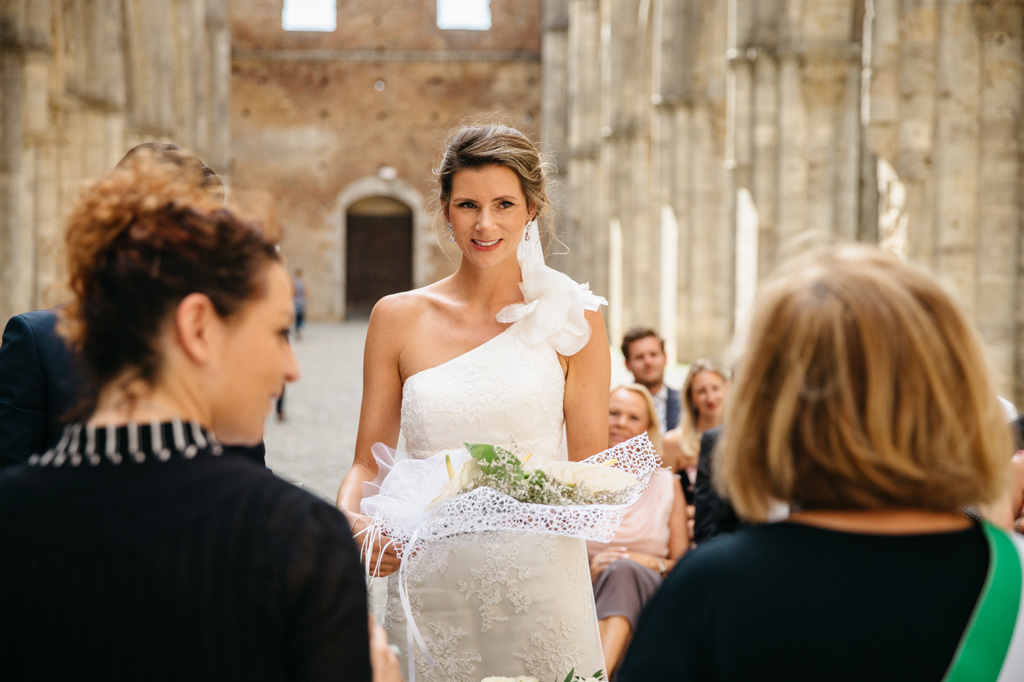 Fotografo Matrimonio Basilica San Galgano Toscana La sposa sorridente ringrazia per i fiori ricevuti