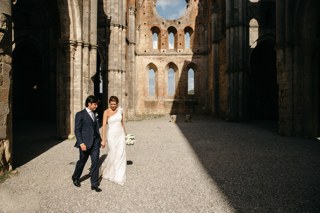 Fotografo Matrimonio Basilica San Galgano Toscana Gli sposi camminano mano nella mano nell'Abbazia di San Galgano ormai vuota
