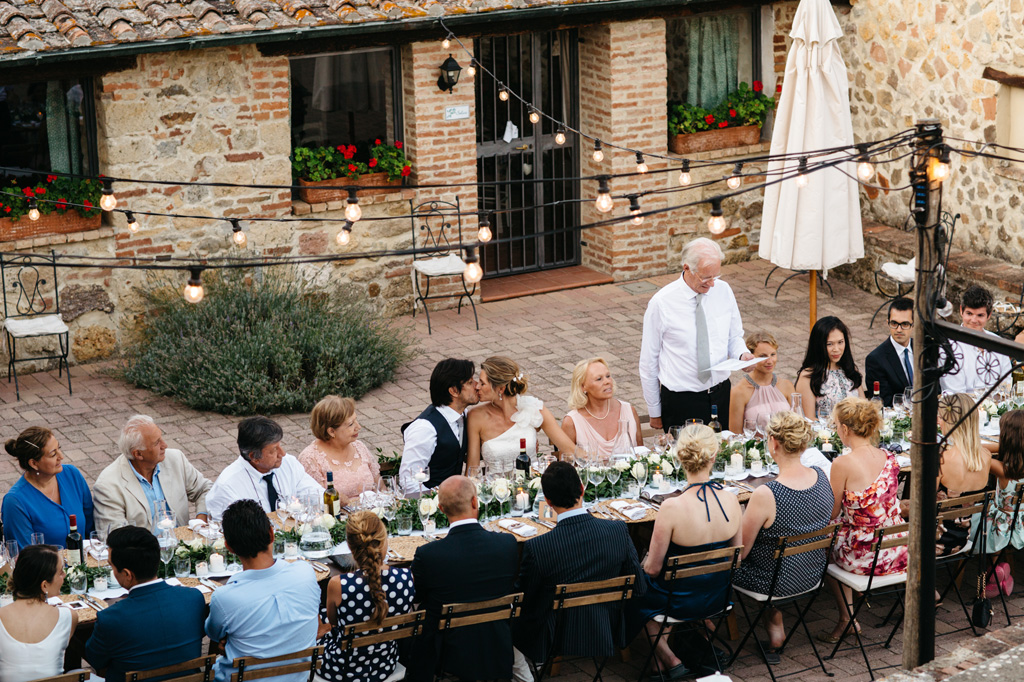 Fotografo Matrimonio Basilica San Galgano Toscana Il padre della sposa legge il discorso scritto per la coppia mentre gli sposi si baciano