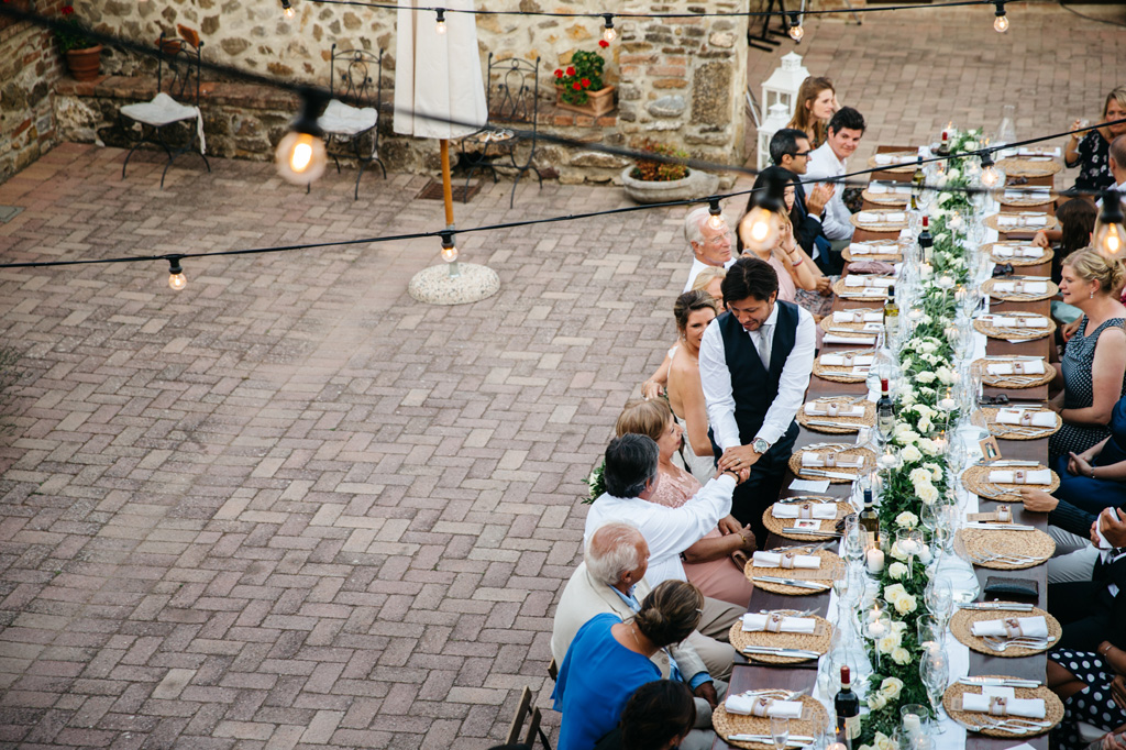 Fotografo Matrimonio Basilica San Galgano Toscana Lo sposo stringe la mano del padre al tavolo del ricevimento