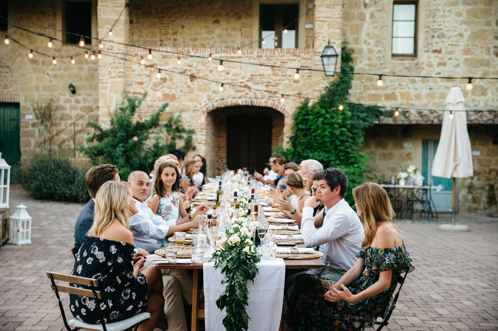 Fotografo Matrimonio Basilica San Galgano Toscana Gli invitati parlano tra di loro al tavolo durante la cena di nozze di Carlos e Catherine