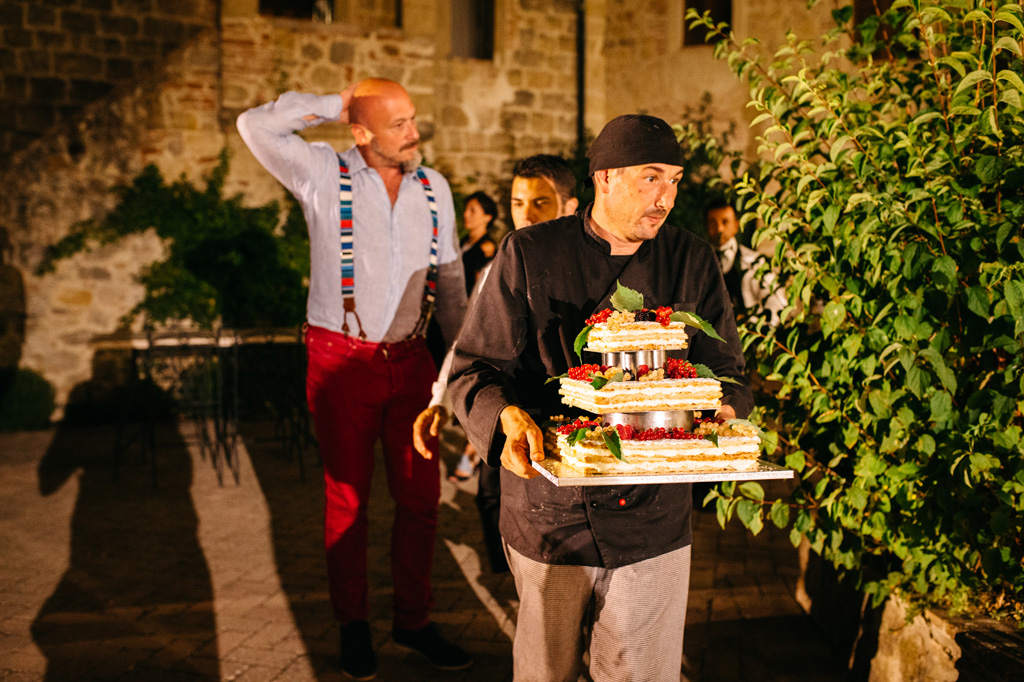 Fotografo Matrimonio Basilica San Galgano Toscana Il particciere porta fuori la torta nuziale