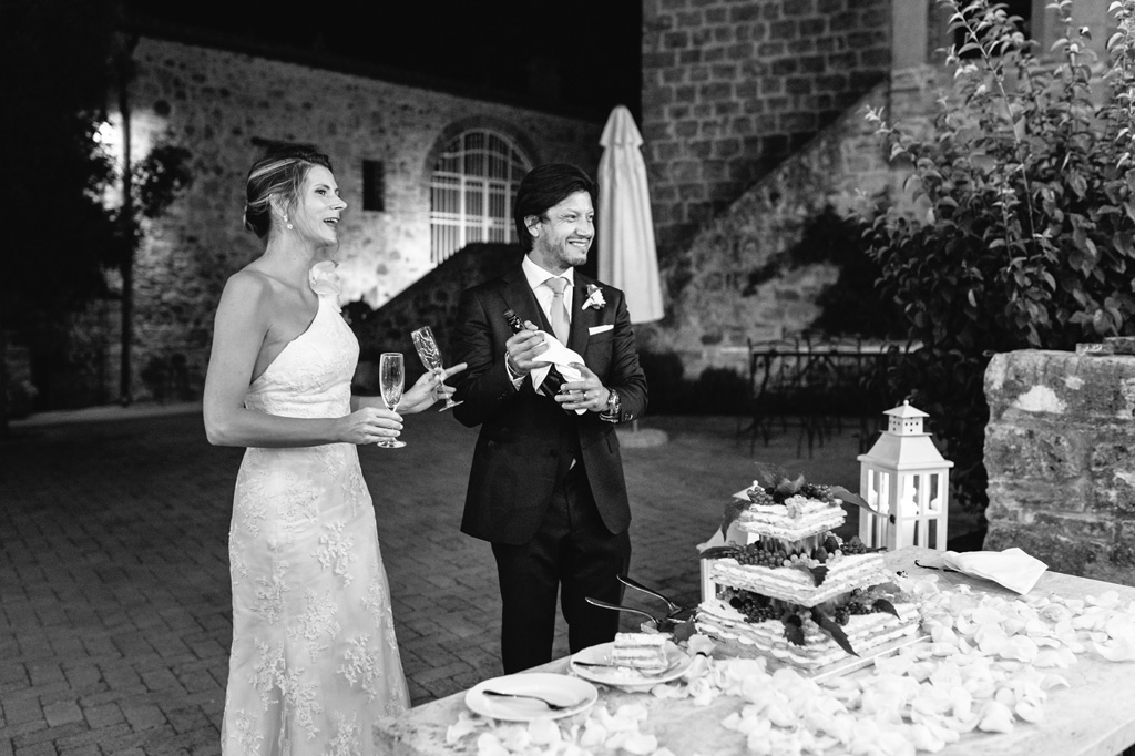 Fotografo Matrimonio Basilica San Galgano Toscana Lo sposo stappa lo champagne dopo il taglio della torta