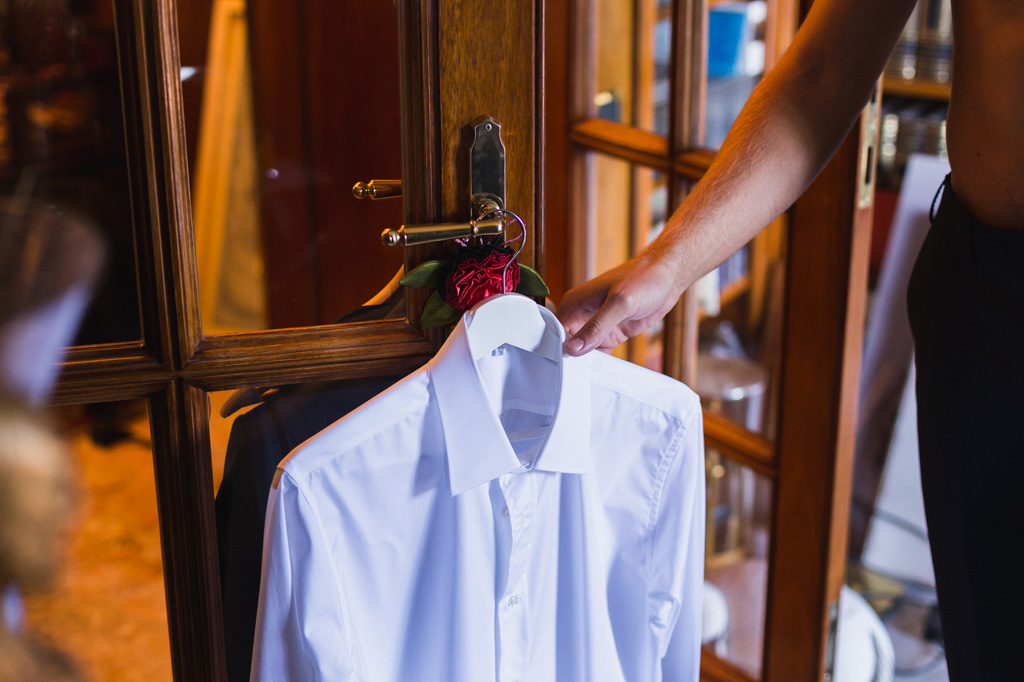 Wedding Photographer Como Lake Lo sposo prende la camicia da indossare