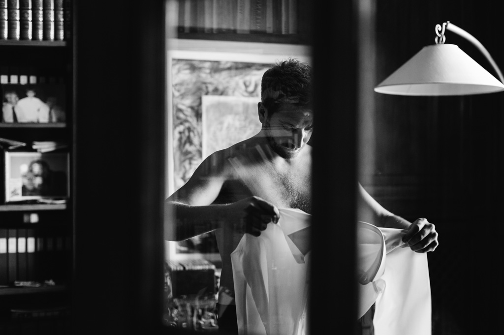 Wedding Photographer Como Lake Lo sposo indossa la camicia nella sua casa di Como