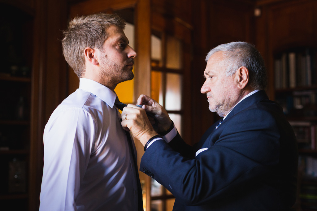 Wedding Photographer Como Lake Il padre aiuta lo sposo a fare il nodo alla cravatta