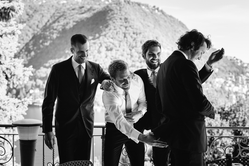 Wedding Photographer Como Lake Lo sposo con gli amici sul balcone della casa sul Lago di Como